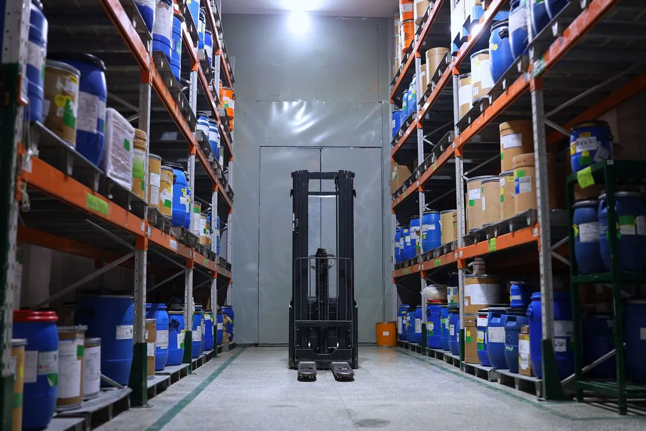 Warehouse aisle with racked goods and a forklift