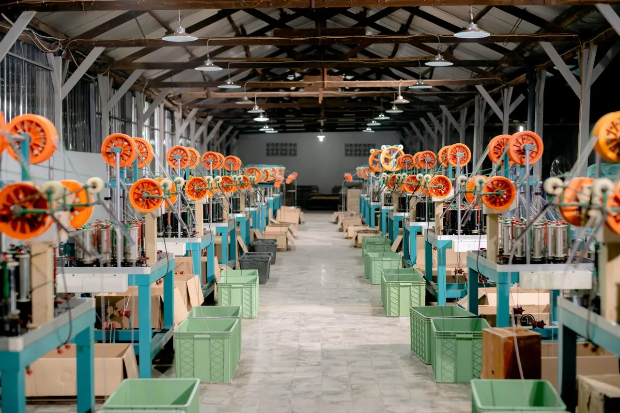Textile spinning mill interior with machines in rows